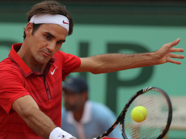 Roger Federer returns against Novak Djokovic  