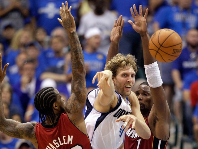 Dirk Nowitzki passes between Udonis Haslem and Chris Bosh 