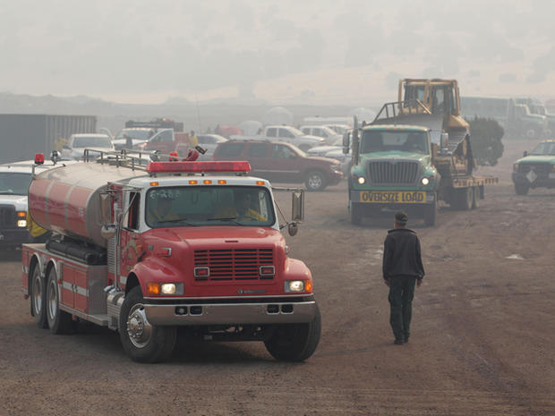 Fire trucks leave a firefighter base camp  