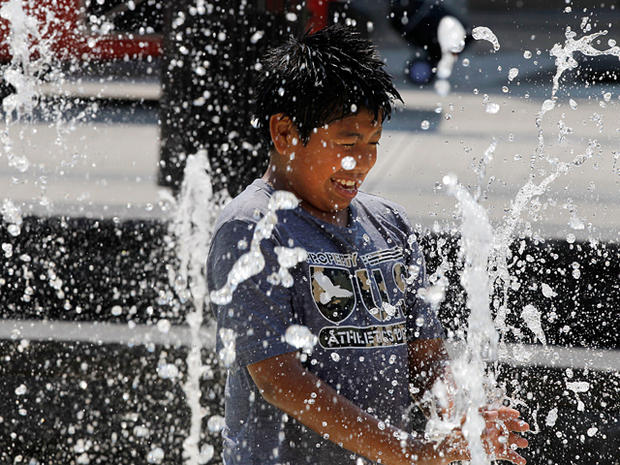 child plays in a water fountain 