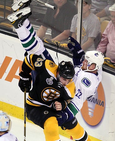 Brad Marchand upends Daniel Sedin 