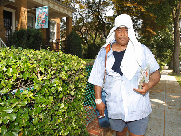 Mailman shields himself from the heat with a towel 