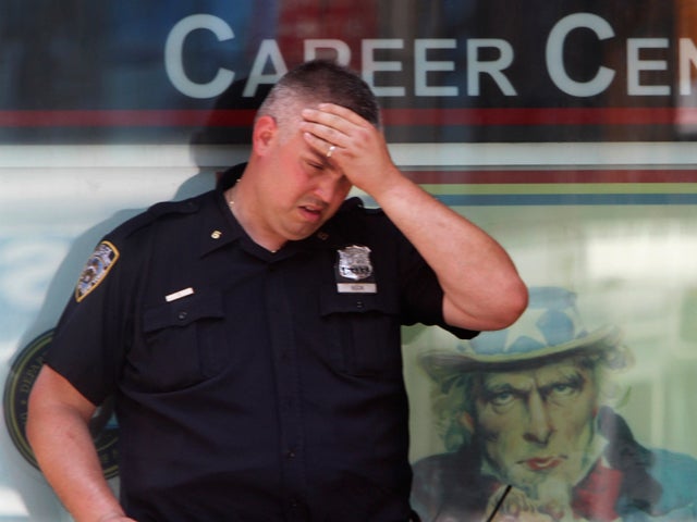 police officer wipes sweat off his forehead 