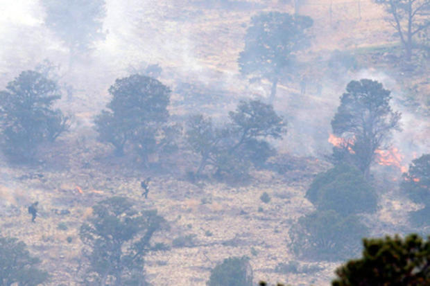 Firefighters walk up a hillside as they fight the Wallow Fire 
