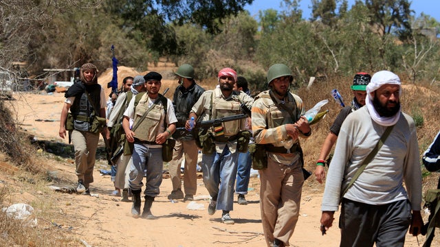 Rebels walking after fighting pro-Qaddafi forces 