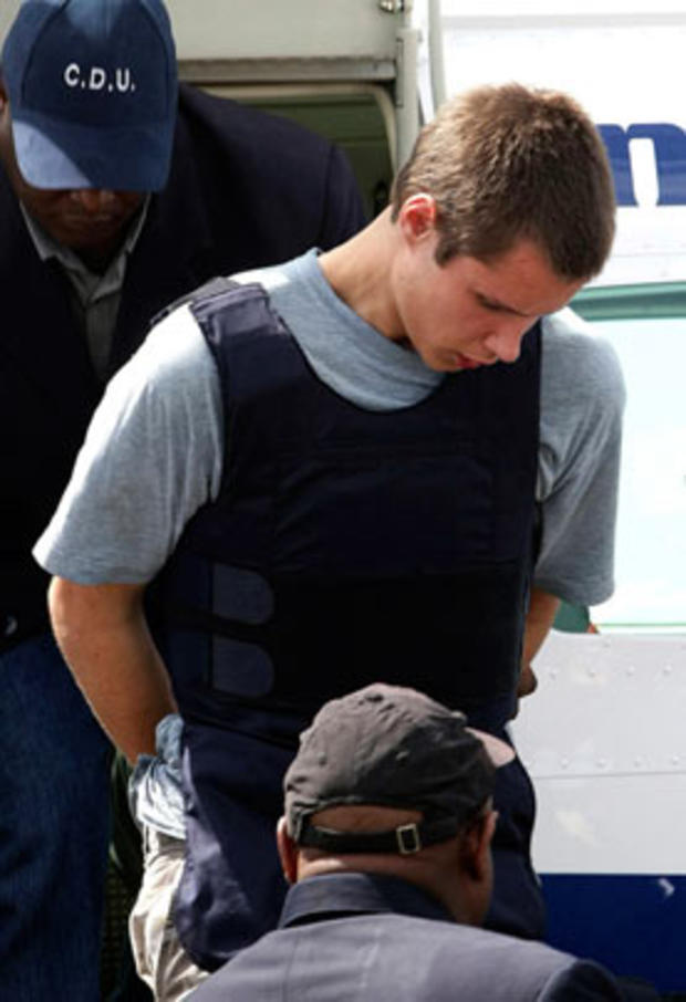 Colton Harris-Moore exits a plane handcuffed as he is escorted by police upon arrival to Nassau, Bahamas, after his arrest before dawn in northern Eleuthera island, on July 11, 2010.  
