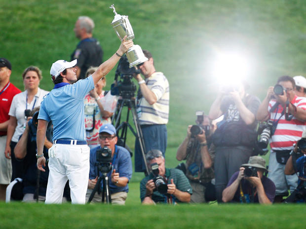 Rory McIlroy holds up the trophy for photographers after winning the U.S. Open Championship golf tournament 