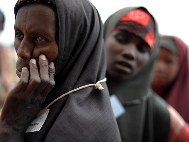 Somali refugees wait in line to recieve aid at a food distribution point 