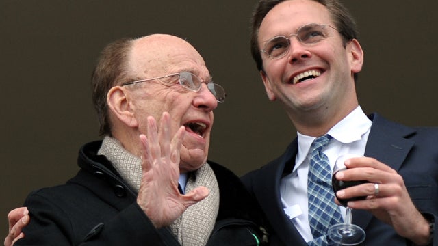 Media mogul Rupert Murdoch, left, stands beside his son James Murdoch on a balcony overlooking horse racing at the Cheltenham Festival March 18, 2010. 