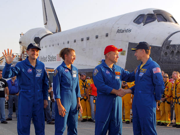 Commander Chris Ferguson, right, shakes hands with co-pilot Doug Hurley after landing Space Shuttle Atlantis at the Kennedy Space Center at Cape Canaveral, Fla., July 21, 2011. The landing of Atlantis marks the end of NASA's 30-year-long space shuttle pro 