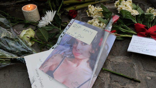 Flowers and messages are left near the house in north London where the body of  Amy Winehouse was found.  