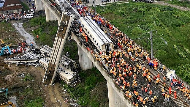 Chinese rescuers work around the wreckage of train cars in Wenzhou, China, July 24, 2011. A bullet train crashed into another high-speed train, killing dozens of people and once again raising safety concerns about the country's fast-expanding rail network 