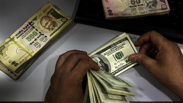 A man counts U.S. dollars at a currency exchange outlet in New Delhi, India, Friday, July 29, 2011.  