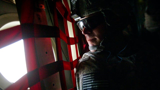 Col. Sean Jenkins, commander of the U.S. Army's 506th Infantry Regiment, 4th Brigade Combat Team, 101st Airborne Division, out of Fort Campbell, Ky., looks out the window aboard a C-130 cargo plane as he begins his trip home after taking off from Forward  