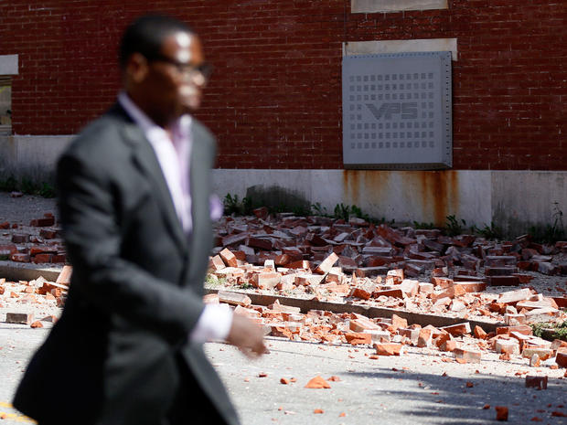 A man walks past bricks that fell off of a house once owned by the late Rep. Parren Mitchell, D-Md., after an earthquake was felt in Baltimore, Aug. 23, 2011. 