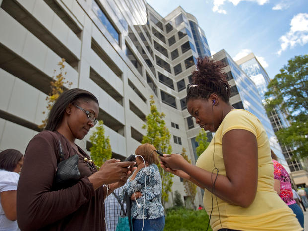 Blue Cross Blue Shield employees Keonna Freeman, left, 28, and Erica Cole, 33, check their mobile devices after a 5.8 magnitude earthquake in central Virginia sent tremors up the east coast, Aug. 23, 2011, in downtown Wilmington, Del.  