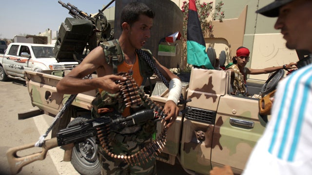 Rebels gather at Libyan leader Muammar Qaddafi's Bab al-Aziziya compound in Tripoli Aug. 24, 2011, as fighting rages in the area a day after it was captured by opposition forces. 