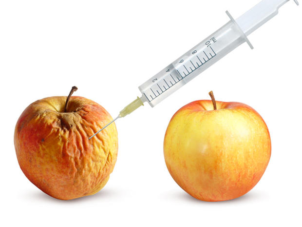 Wrinkled apple and a nice apple and syringe 