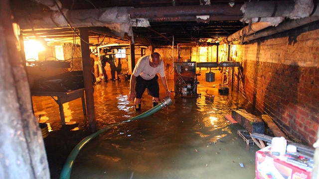 Nick Feola tries to get the gallons of water out of his basement at his home of 32 years on 5th Street in Hoboken, N.J.  