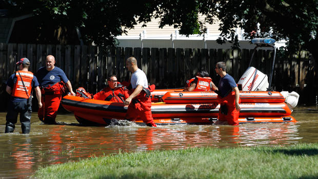 Rescue workers pull a boat with a woman as they wade through floodwaters caused by Hurricane Irene, Aug. 29, 2011, Pompton Lakes, N.J.  