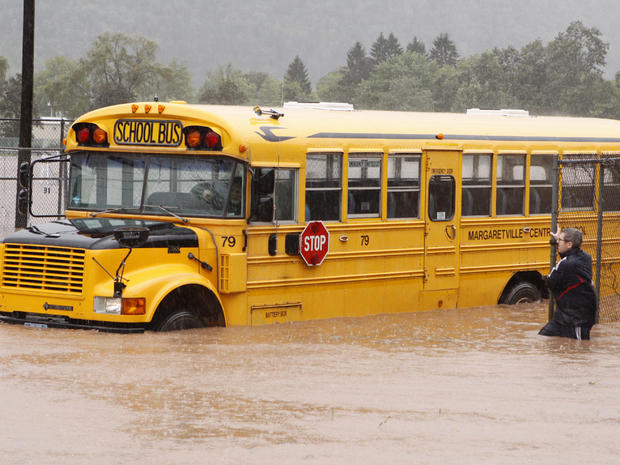 Margaretville Central School Athletic Director Jeremey Marks stands next to a school bus in floodwaters , Aug. 28, 2011, in Margaretville, N.Y.  