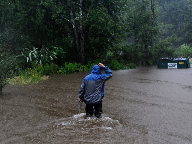 Leonard Runnells wades into his yard in Springfield, Vt., to tie down a dumpster in rising floodwatersAug. 28, 2011.  