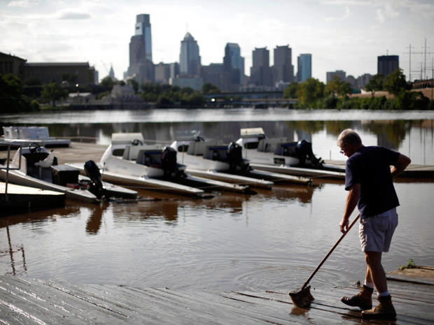 Jim Lang sweeps silt left behind from floodwaters of the Schuylkill River at the Penn Athletic Club on Boathouse Row in Irene's aftermath , Aug. 29, 2011, in Philadelphia. 