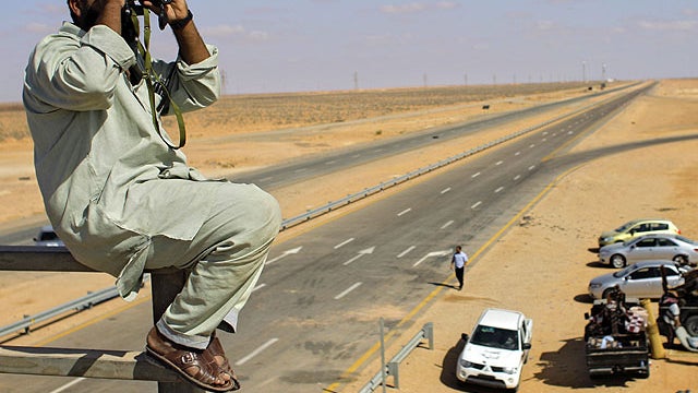 A rebel fighter observes landscape at a rebel checkpoint some 80 kilometers from rebel-held Misrata, and some 167 kilometers from pro-Qaddafi-held Sirte, LIbya, Aug. 30, 2011. 
