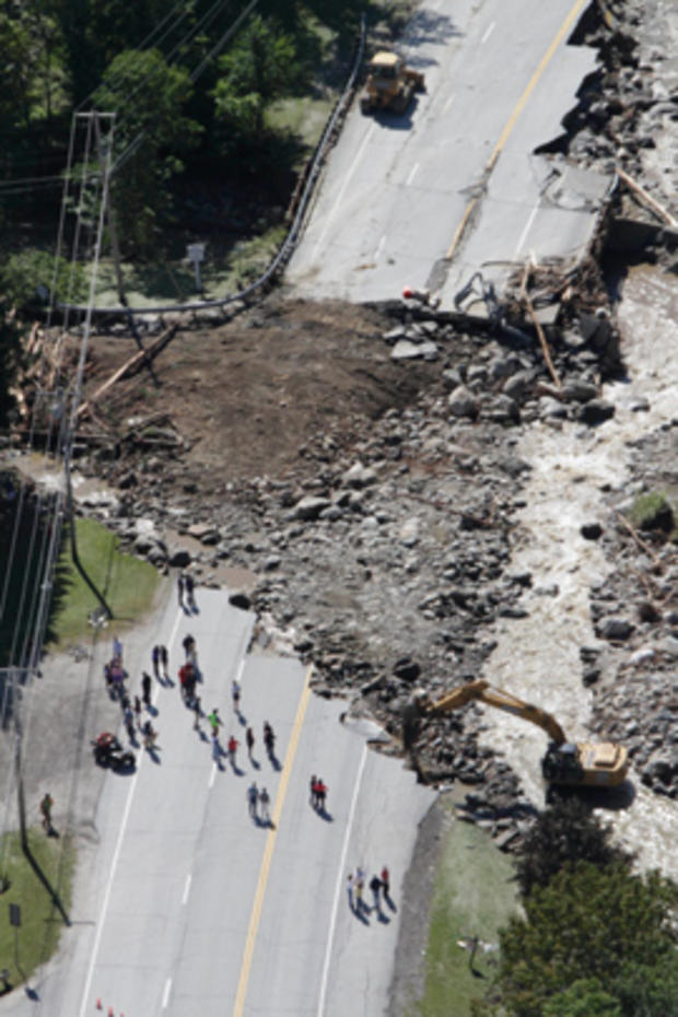 In this aerial photo people gather alongside workers making repairs Tuesday, Aug. 30, 2011 on Route 4 in Killington, Vt., washed out by flood waters from Tropical Storm Irene 