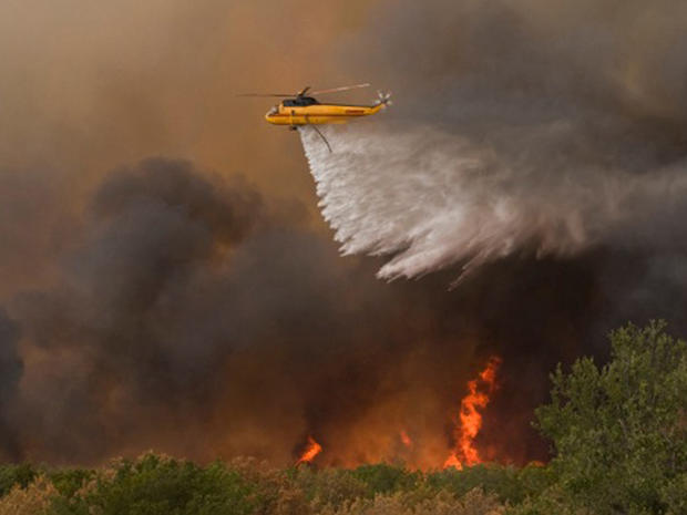 Helicopter drops water on a wildfire near Possum Kingdom Lake, Texas 