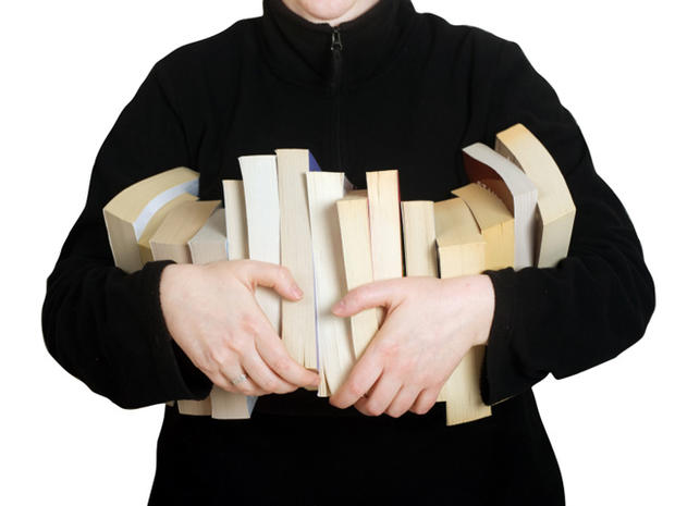 Model holding row of paperback books. 