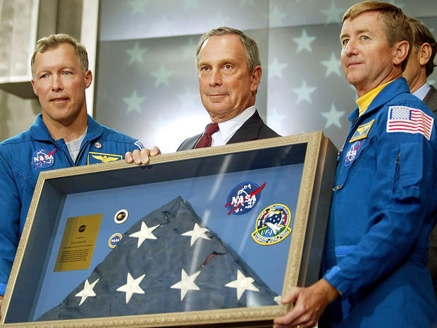 NASA astronauts Dominic Gorie, left, and Frank Culbertson present an American flag to New York City Mayor Michael Bloomberg in honor of Flag Day June 14, 2002, in New York City. The flag was found at ground zero and was flown into space in December 2001 a 
