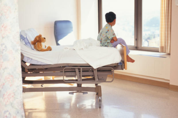 Young boy sitting on hospital bed 