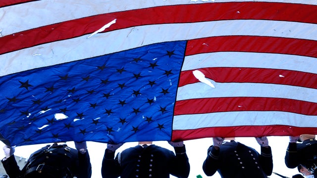 An honor guard carries a flag found at ground zero at the beginning of the annual 9/11 memorial service Sept. 11, 2010, in New York City. 