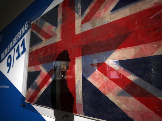 The shadow of a visitor to The Imperial War Museum North in Manchester, England, views Sept. 8, 2011, a Union Jack flag recovered from the wreckage of the 9/11 attack on the World Trade Center. For the 10th anniversary of the terror attack, museum visitor 
