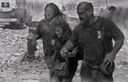 People walk through dust and debris from collapse of World Trade Center 