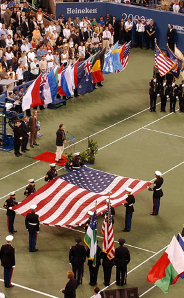 An honor guard displays the flag from the World Trade Center on the opening night of the U.S. Open Sept. 26, 2002, in Queens, N.Y., for the first U.S. Open played since the Sept. 11, 2001, attacks. 