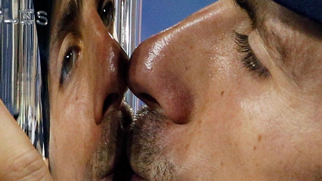 Novak Djokovic kisses the trophy after winning the men's championship 