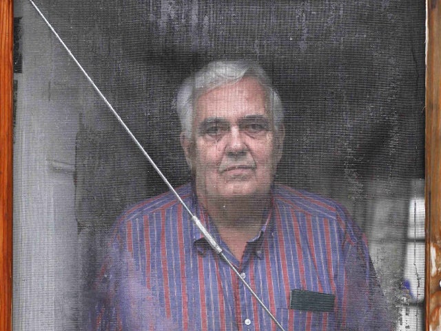 Bill Ricker looks out the screen door of his trailer home 