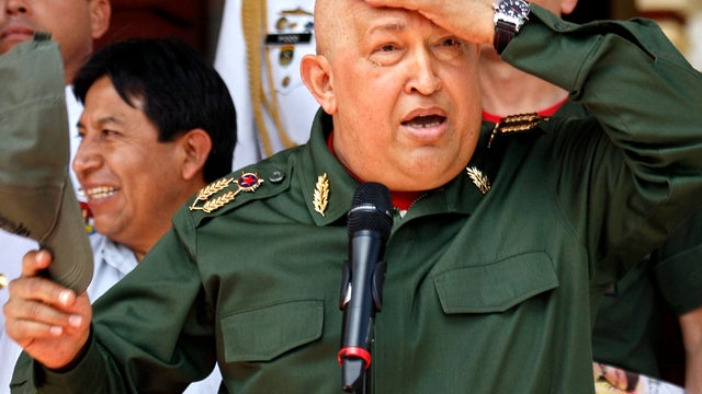 Venezuelan President Hugo Chavez takes his cap off during a welcoming ceremony for Bolivian President Evo Morales at the Miraflores presidential palace in Caracas, Venezuela, Sept. 17, 2011. 