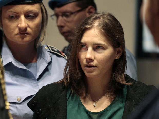 Amanda Knox is escorted as she arrives for an appeal hearing  