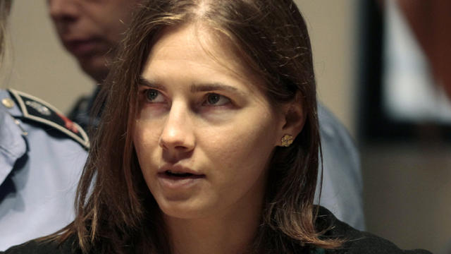 Amanda Knox is escorted as she arrives for an appeal hearing 