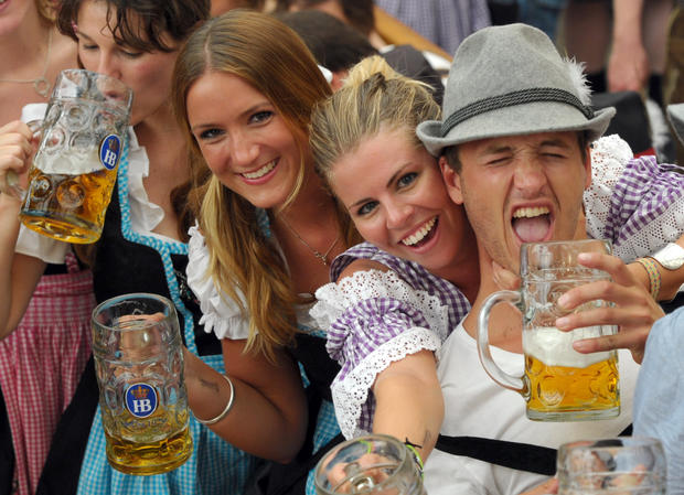 Visitors hold their beer mugs in a festi 