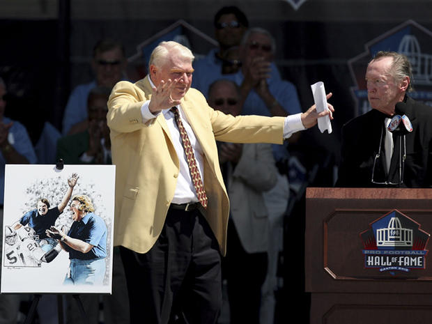 John Madden gestures in front of a portrait of him after being introduced by Al Davis  