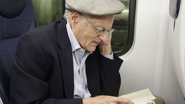 American economist Thomas Sargent takes a phone call while seated on a train in New York Monday, Oct. 10, 2011, shortly after learning that he and fellow American Christopher Sims had won the Nobel Prize for Economics.  