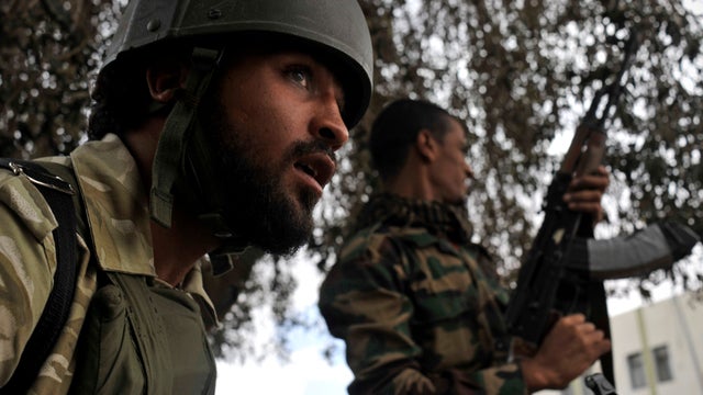 Libyan revolutionary fighters look for forces loyal to Muammar Qaddafi in downtown Sirte, Libya, Oct. 11, 2011. Rebel forces have besieged Sirte since mid-September and are facing fierce resistance from loyalists while fighting street by street inside the 