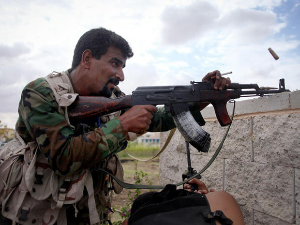 A revolutionary fighter fires at Gadhafi loyalist positions in Sirte, Libya, Thursday, Oct. 13, 2011. Anti-Gadhafi fighters have been closing in on armed supporters of the fugitive leader in Sirte, the most important of two major cities yet to be cleared of loyalists more than two months after the fall of Tripoli. 