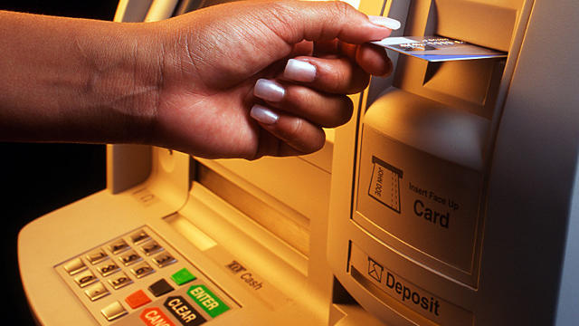 Woman making transaction at ATM machine. 