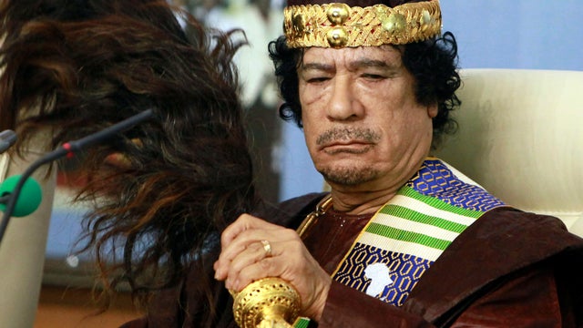 Libyan strongman Muammar Qaddafi fans his face during the Forum of Kings, Princes, Sultans, Sheikhs and Mayors of Africa in the capital city of Tripoli Sept. 8, 2010. 