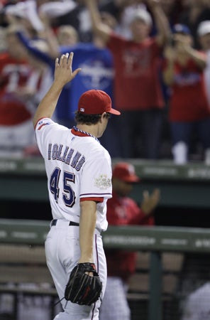 Derek Holland waves to the crowd 